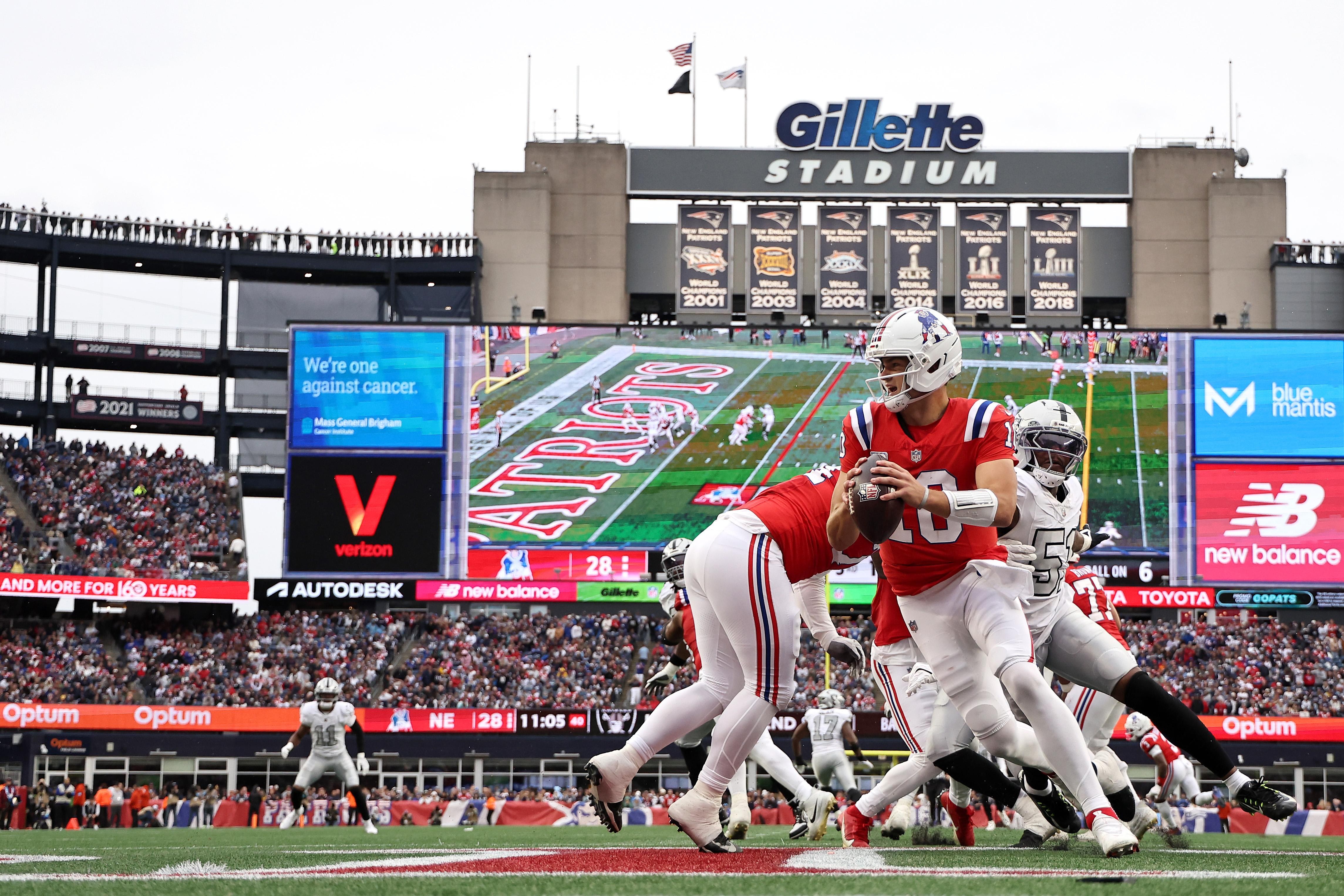Drake Maye lança sob pressão da defesa dos Raiders no Gillette Stadium.