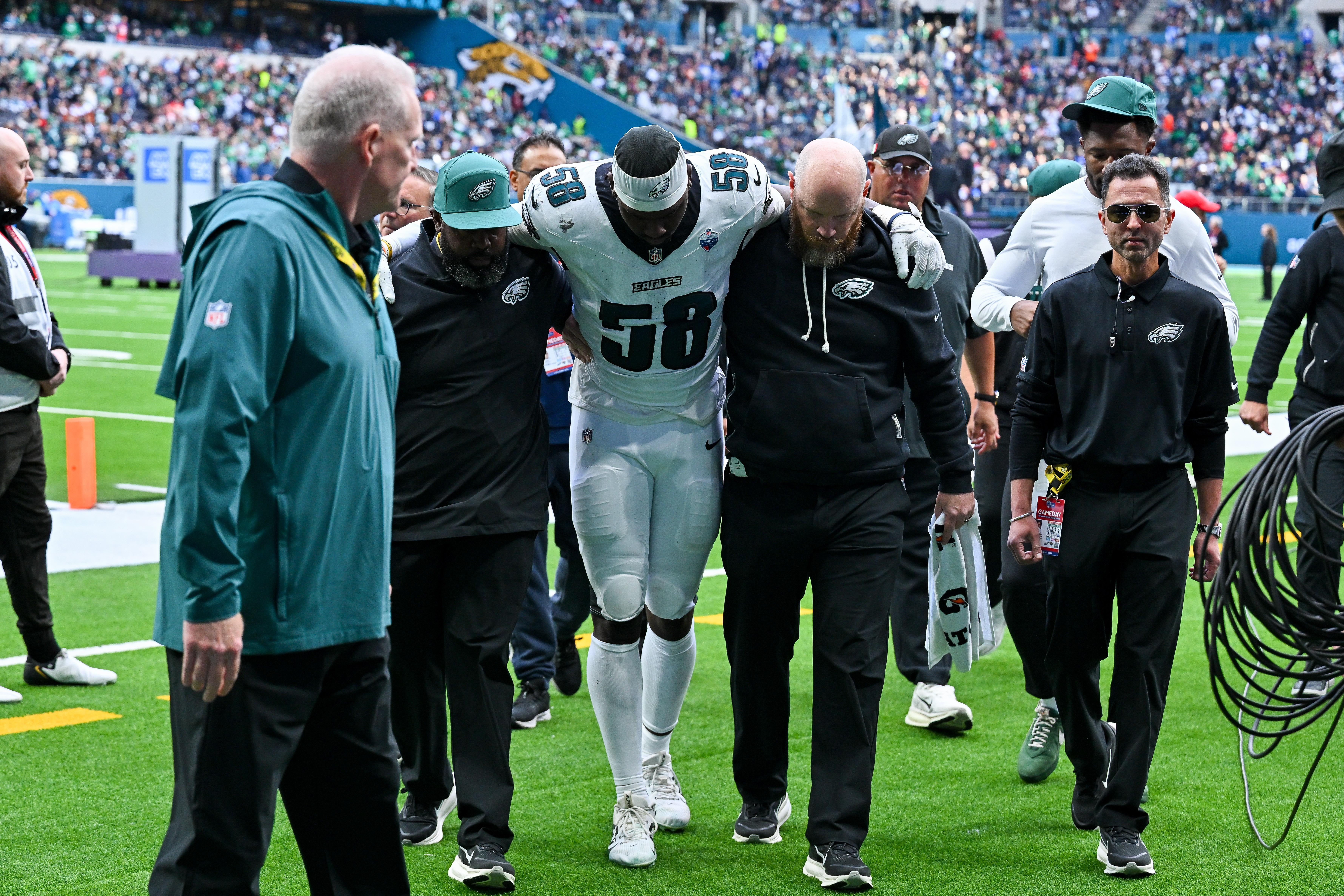 Jogador dos Eagles deixa o campo acompanhado pela equipe médica em Londres.