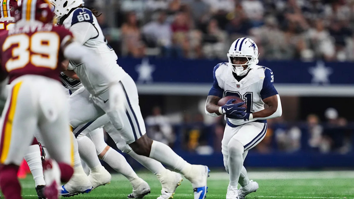 Emari Demercado carrega a bola pelos Dallas Cowboys.