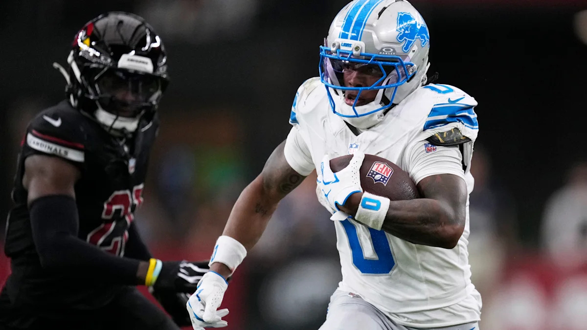 Jahmyr Gibbs corre com a bola pelos Lions contra os Cardinals.