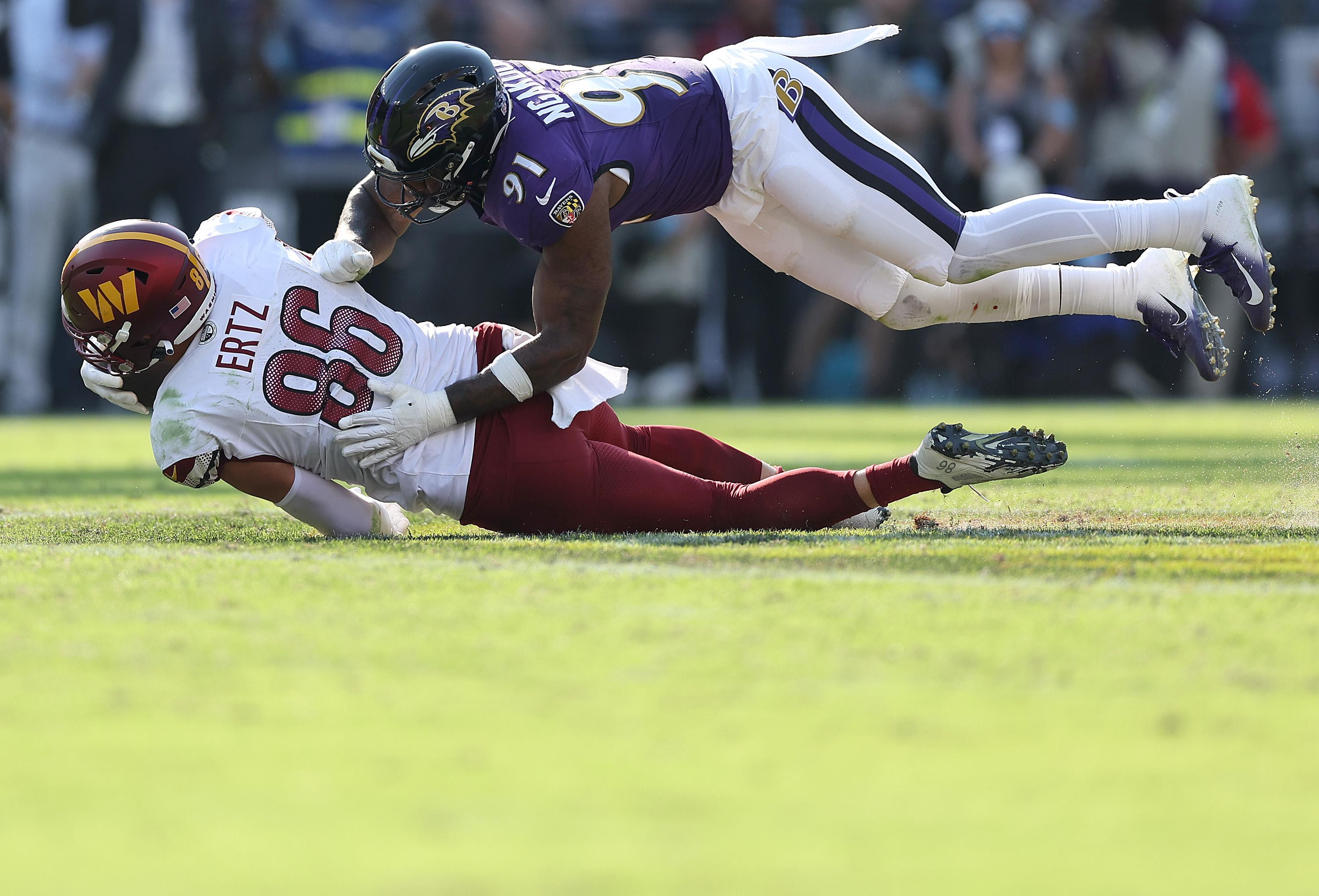 Yannick Ngakoue, então pelos Ravens, derruba Zach Ertz, dos Commanders.