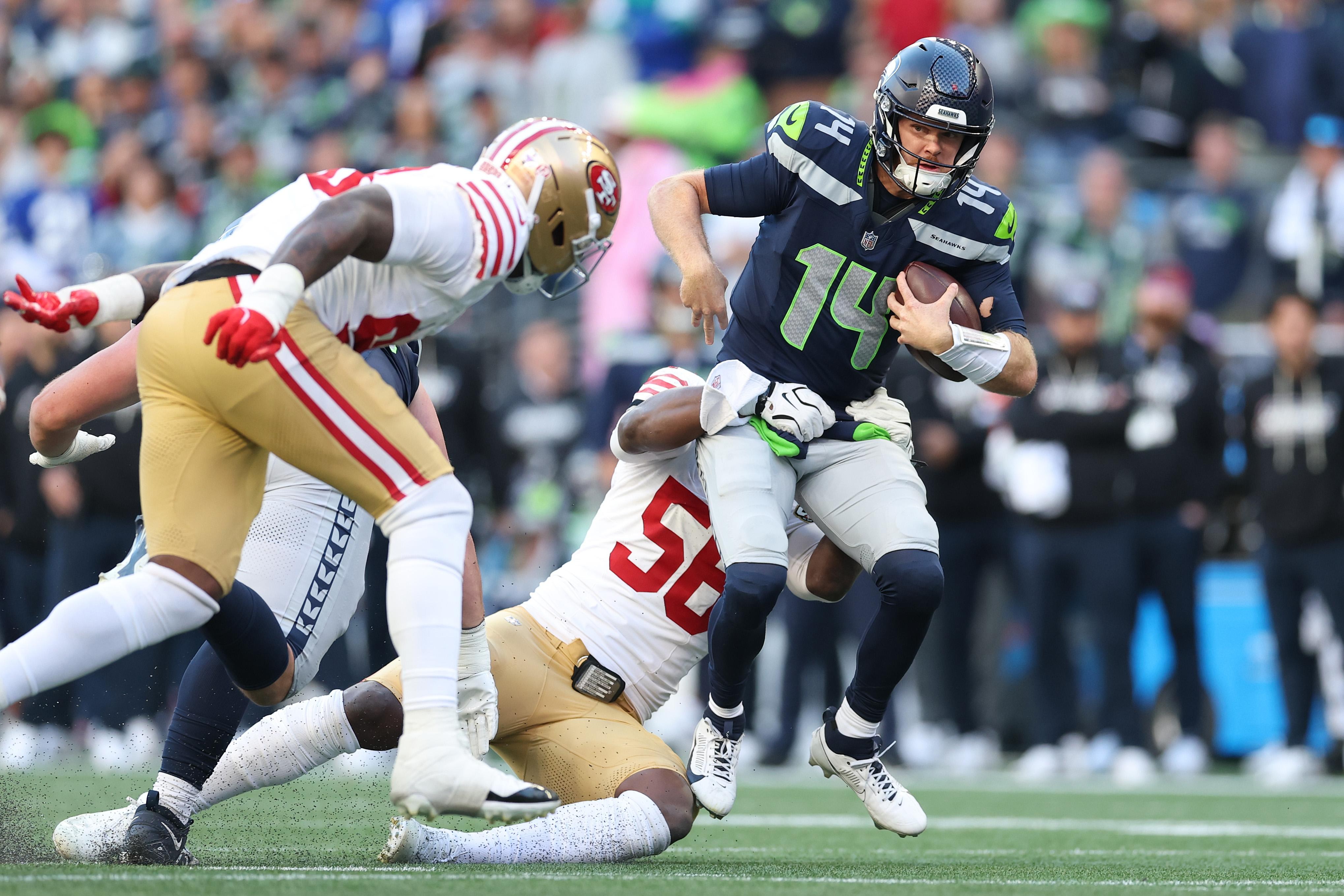 Jaxon Smith-Njigba carrega a bola pelos Seahawks diante dos 49ers.