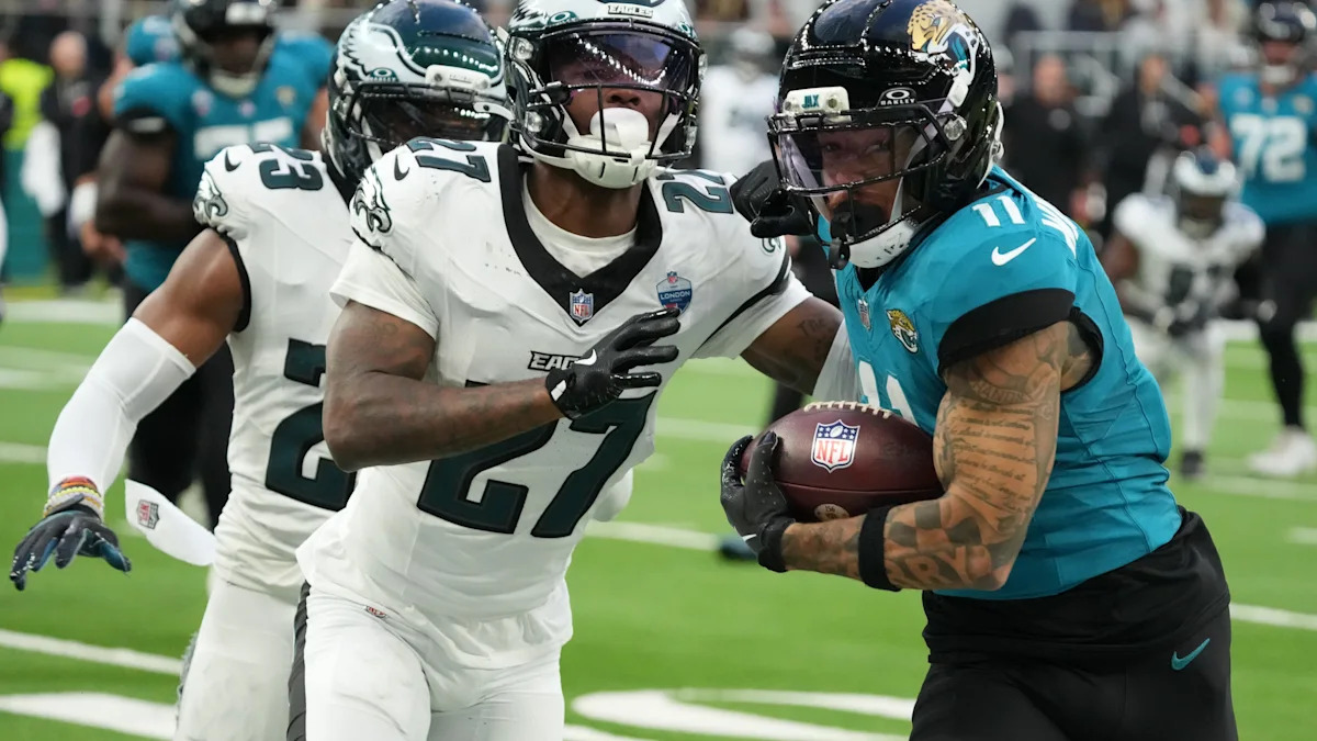 Defensores dos Eagles contêm um jogador dos Jaguars em Londres.