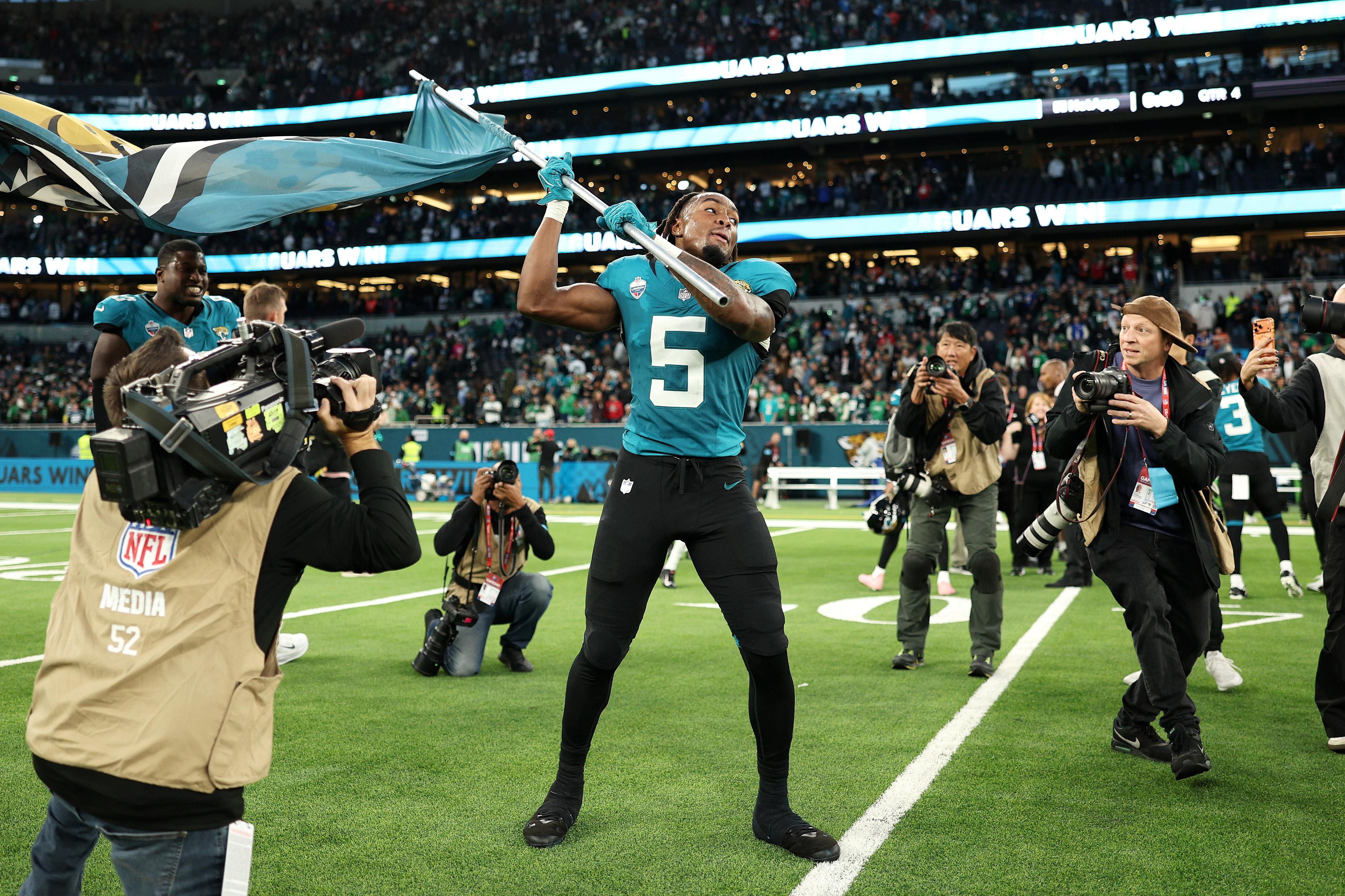 Jogador dos Jaguars comemora com uma bandeira após o jogo em Londres.