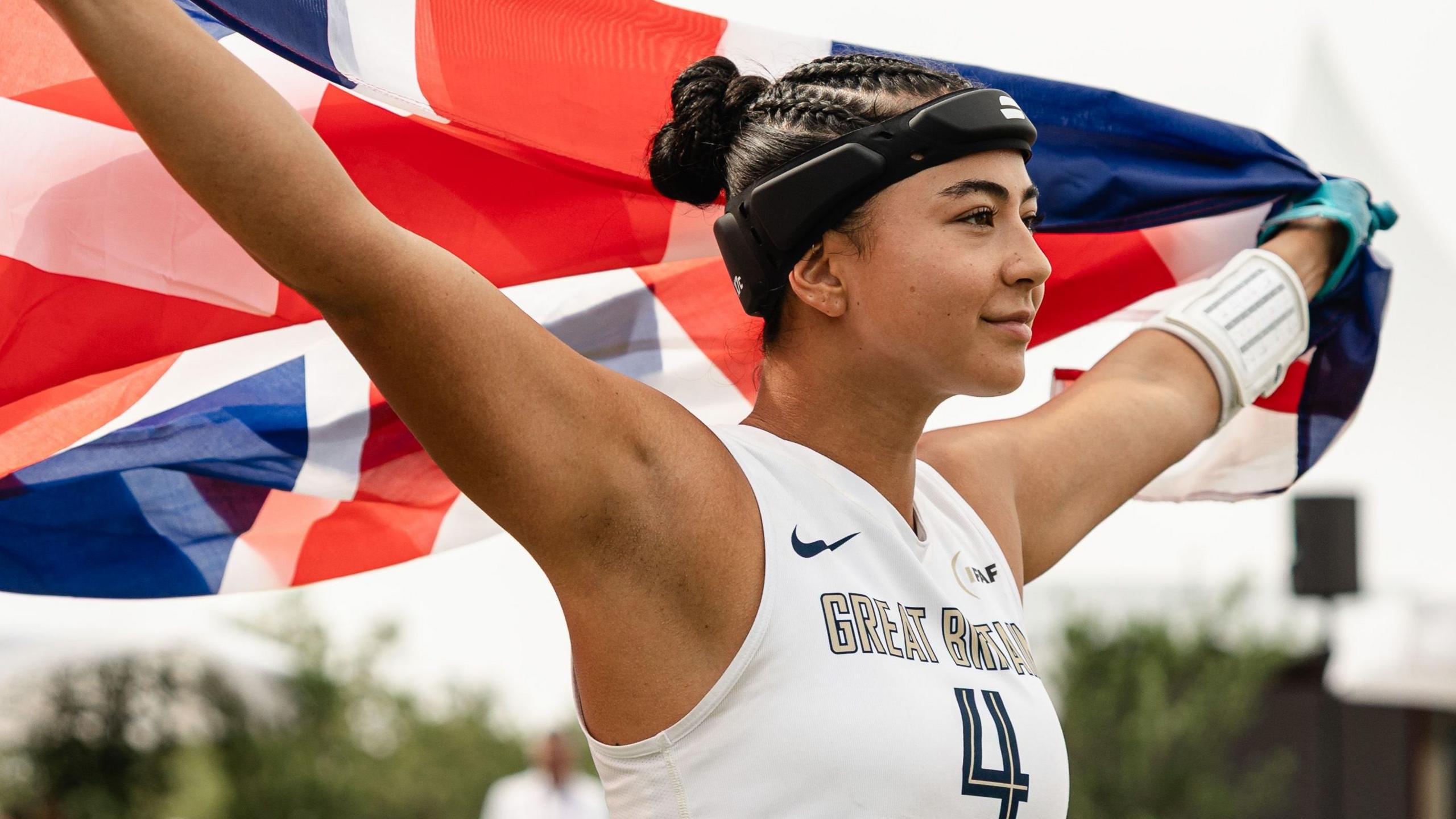 Angelica Tait ergue a bandeira da Grã-Bretanha durante o Mundial de flag football de 2026.