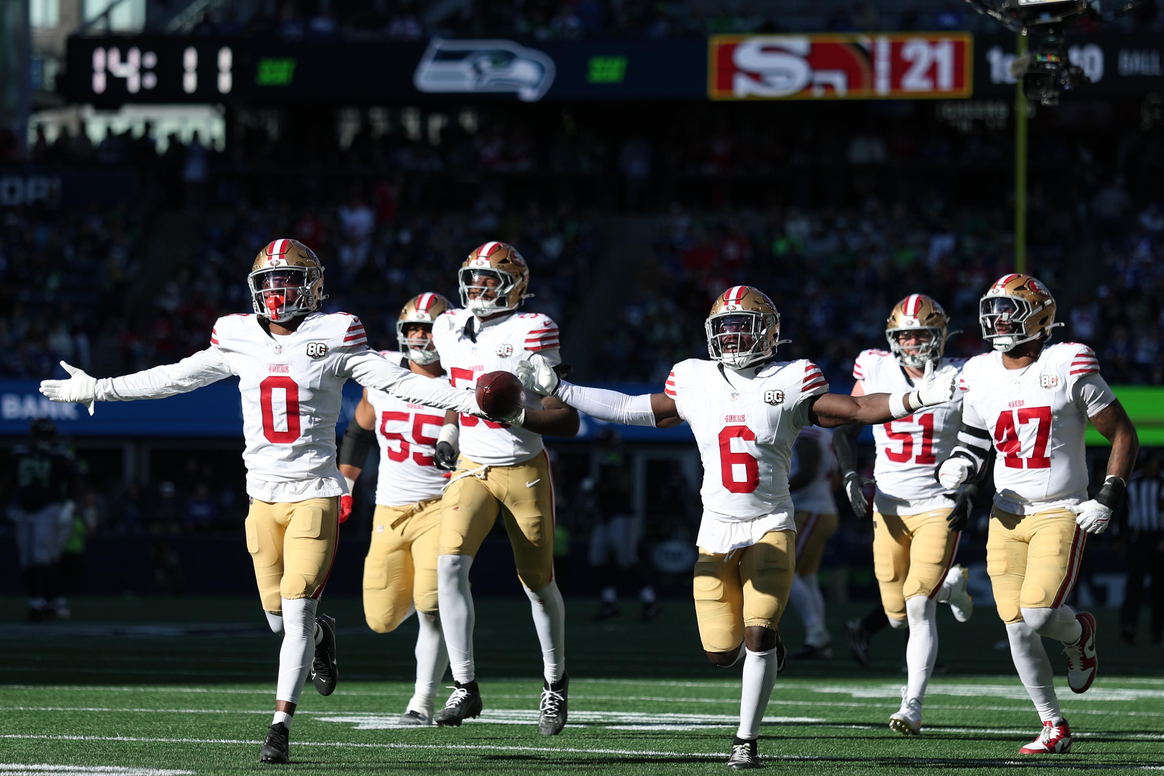Jogadores dos 49ers comemoram uma interceptação contra os Seahawks.