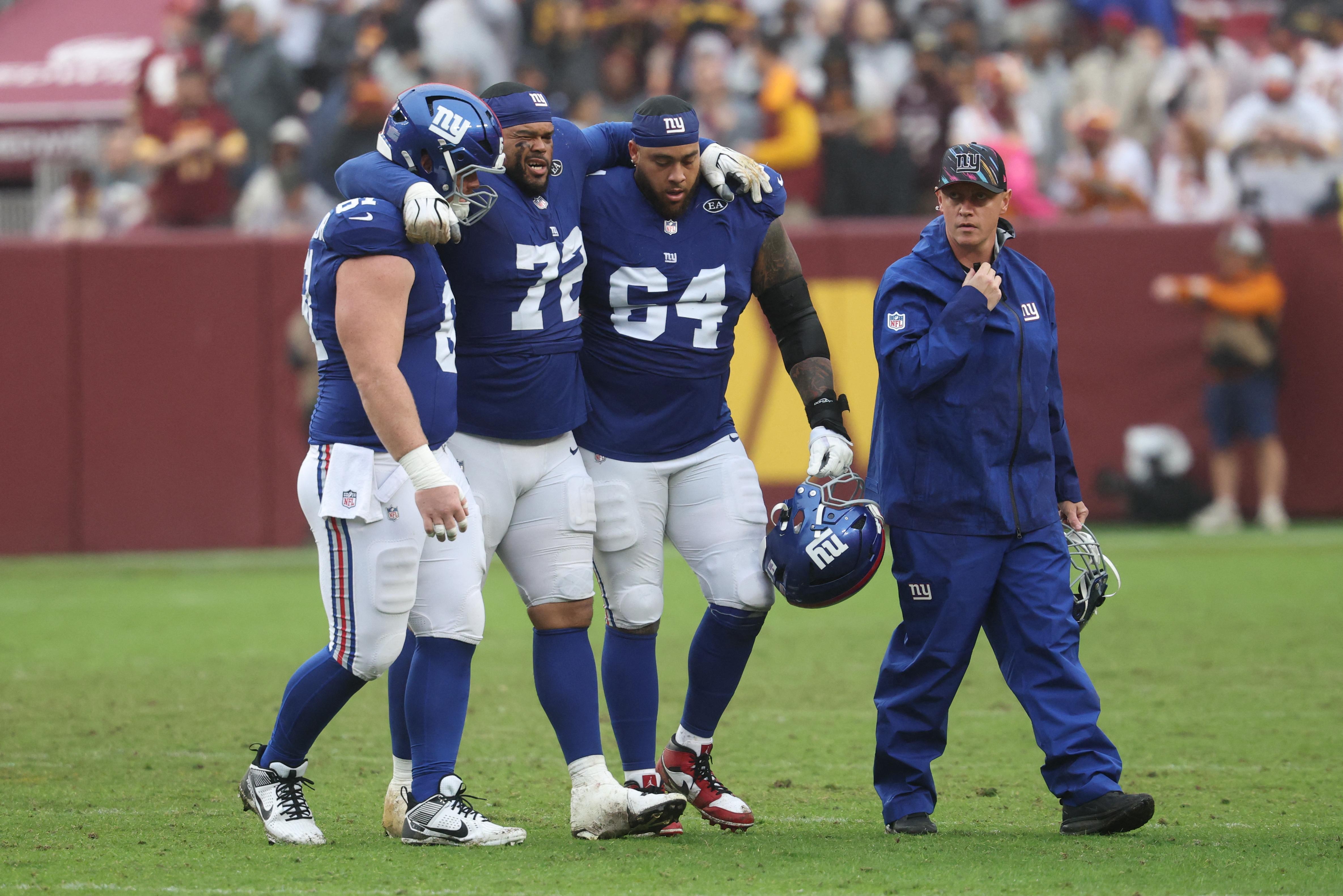 Jermaine Eluemunor recebe ajuda para deixar o campo em Giants x Commanders.