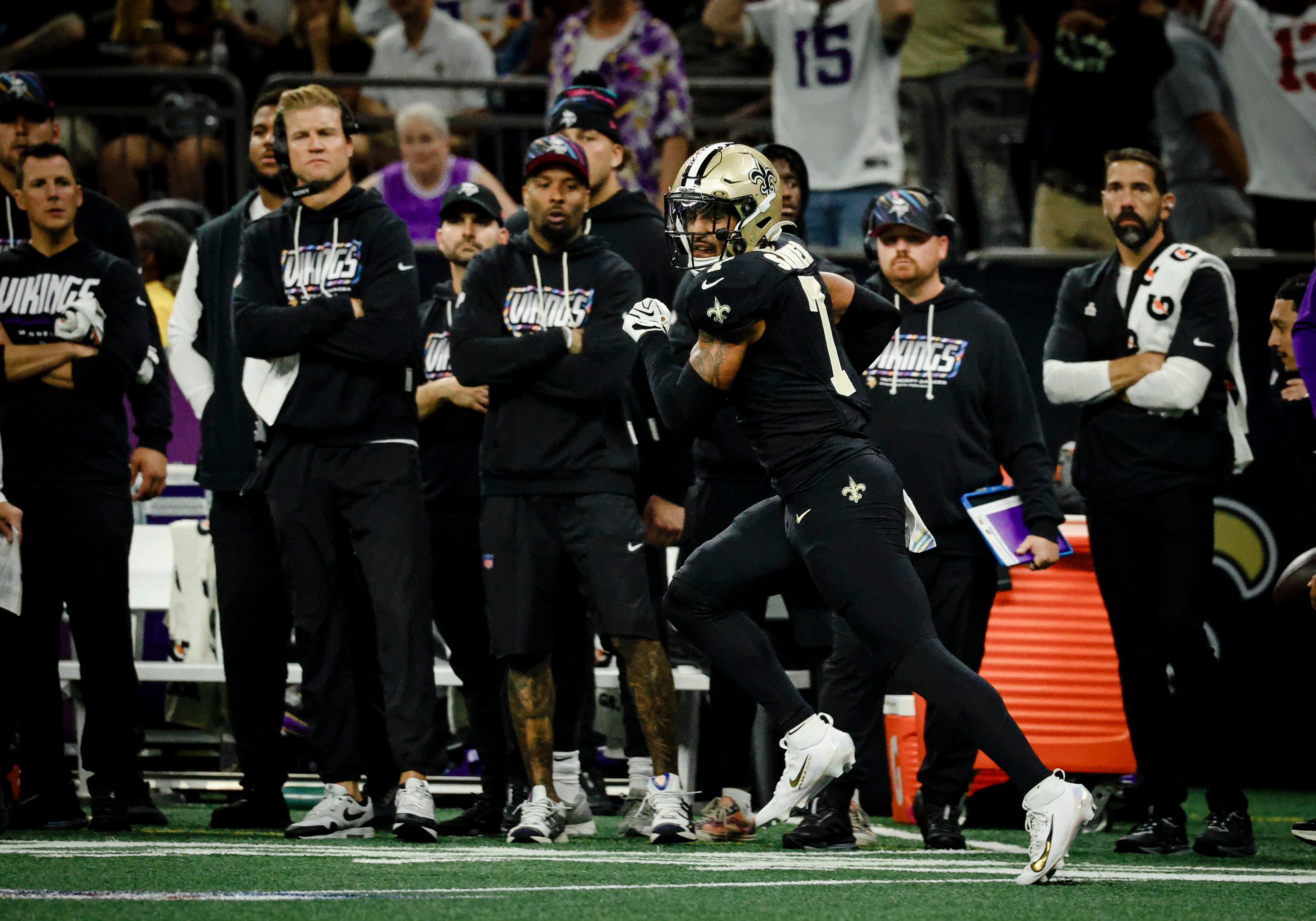 Kellen Moore e a comissão dos Saints acompanham uma partida.