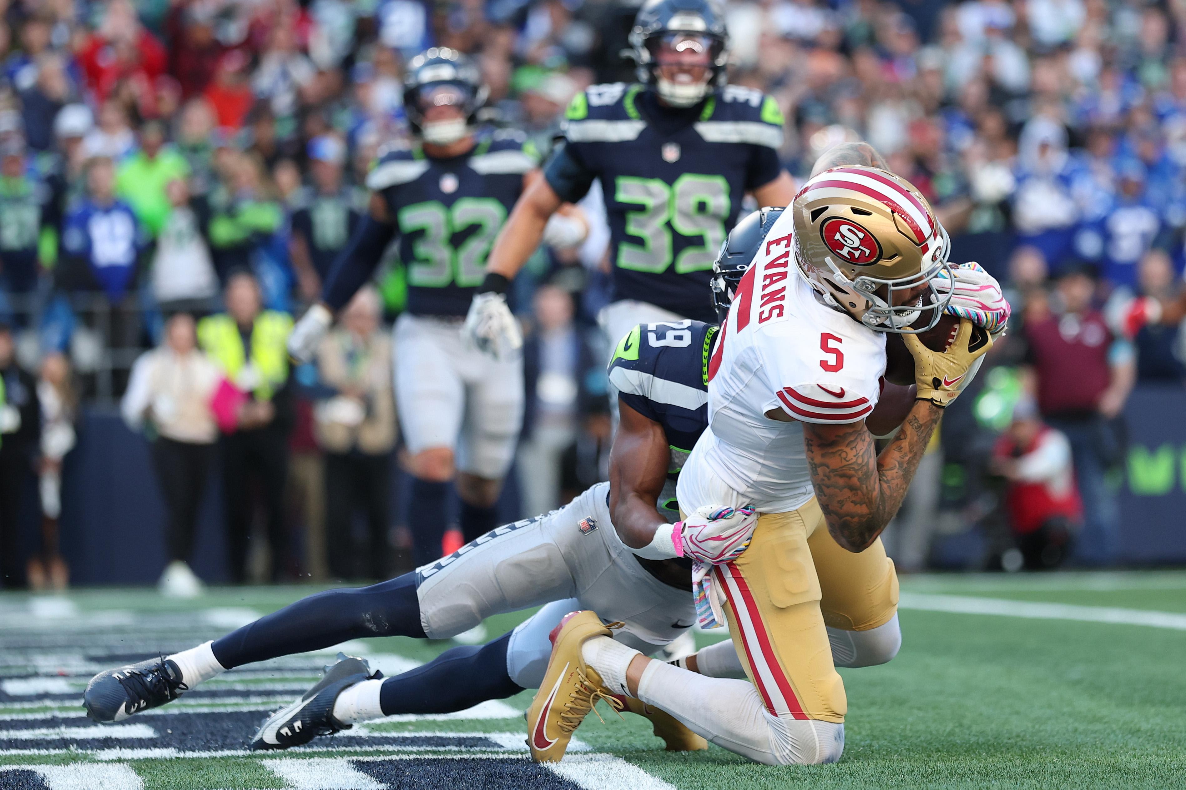 Jogadores de Seahawks e 49ers disputam uma jogada.