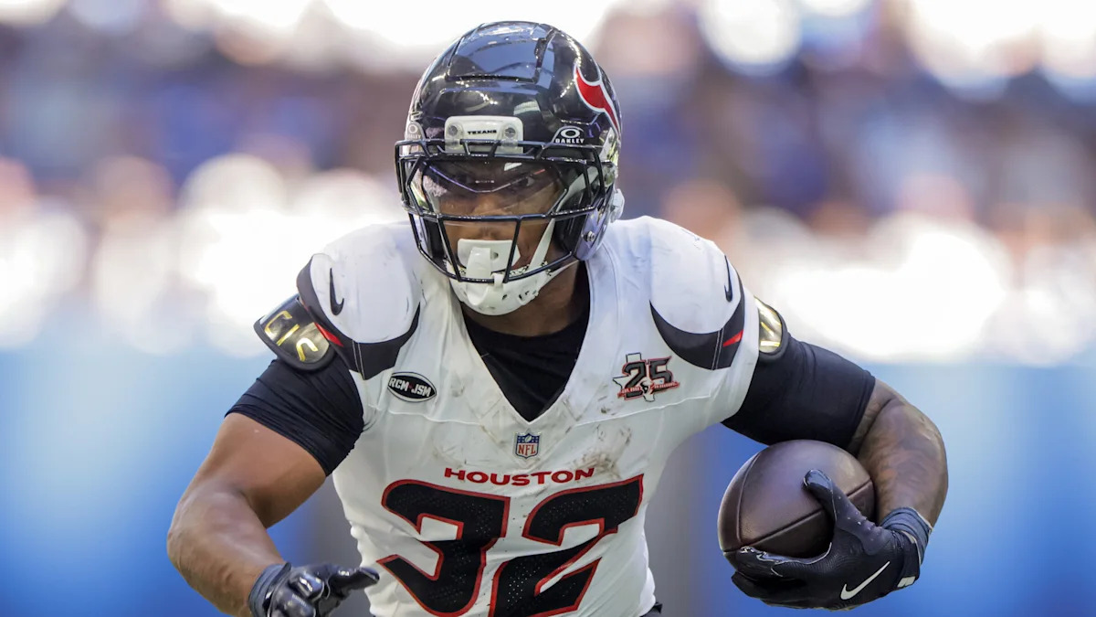 Running back dos Texans em ação com a bola.