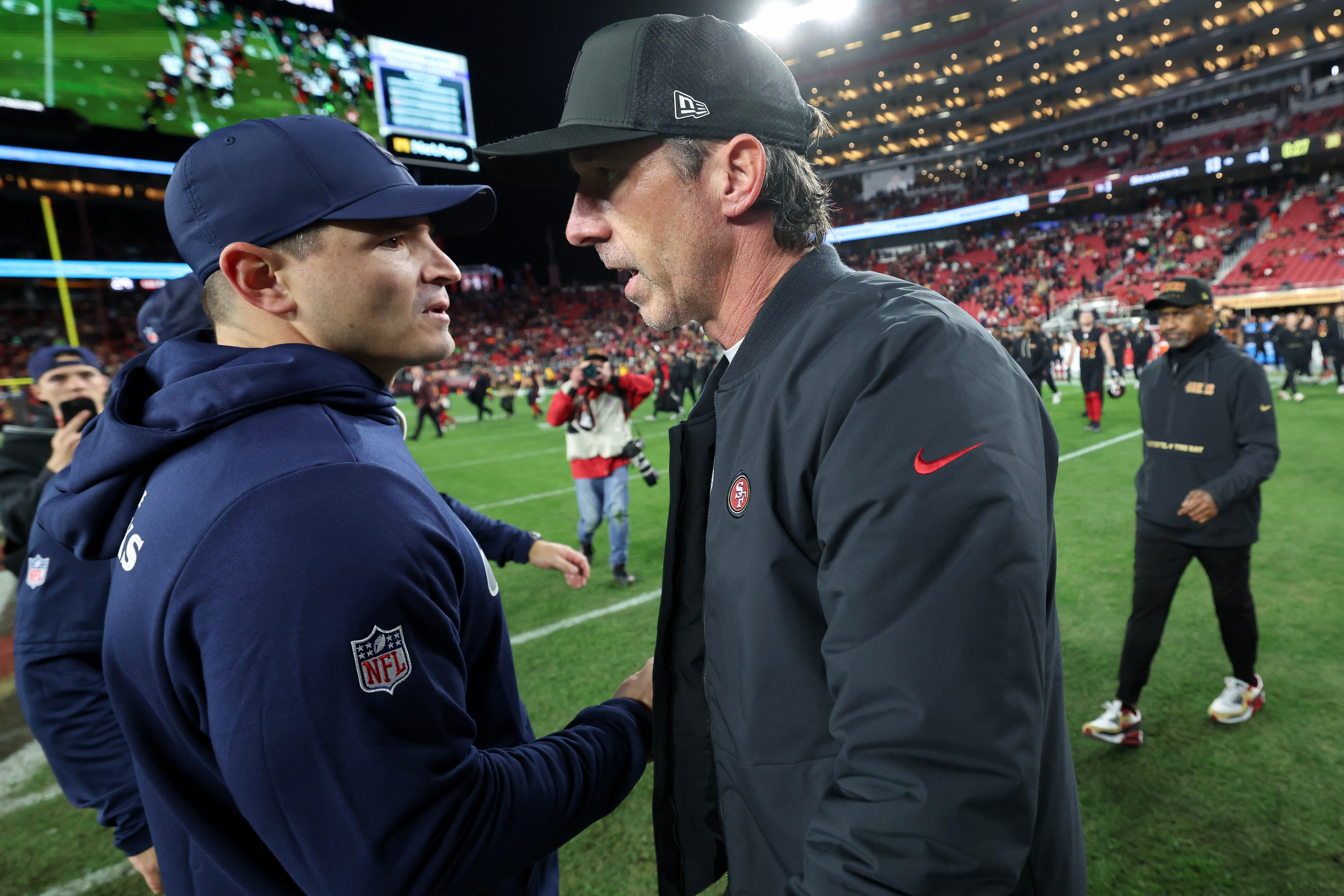 Mike Macdonald e Kyle Shanahan se cumprimentam antes de uma partida.