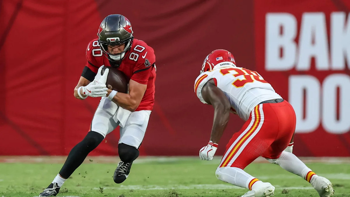 Recebedor dos Buccaneers avança com a bola diante de um defensor dos Chiefs.
