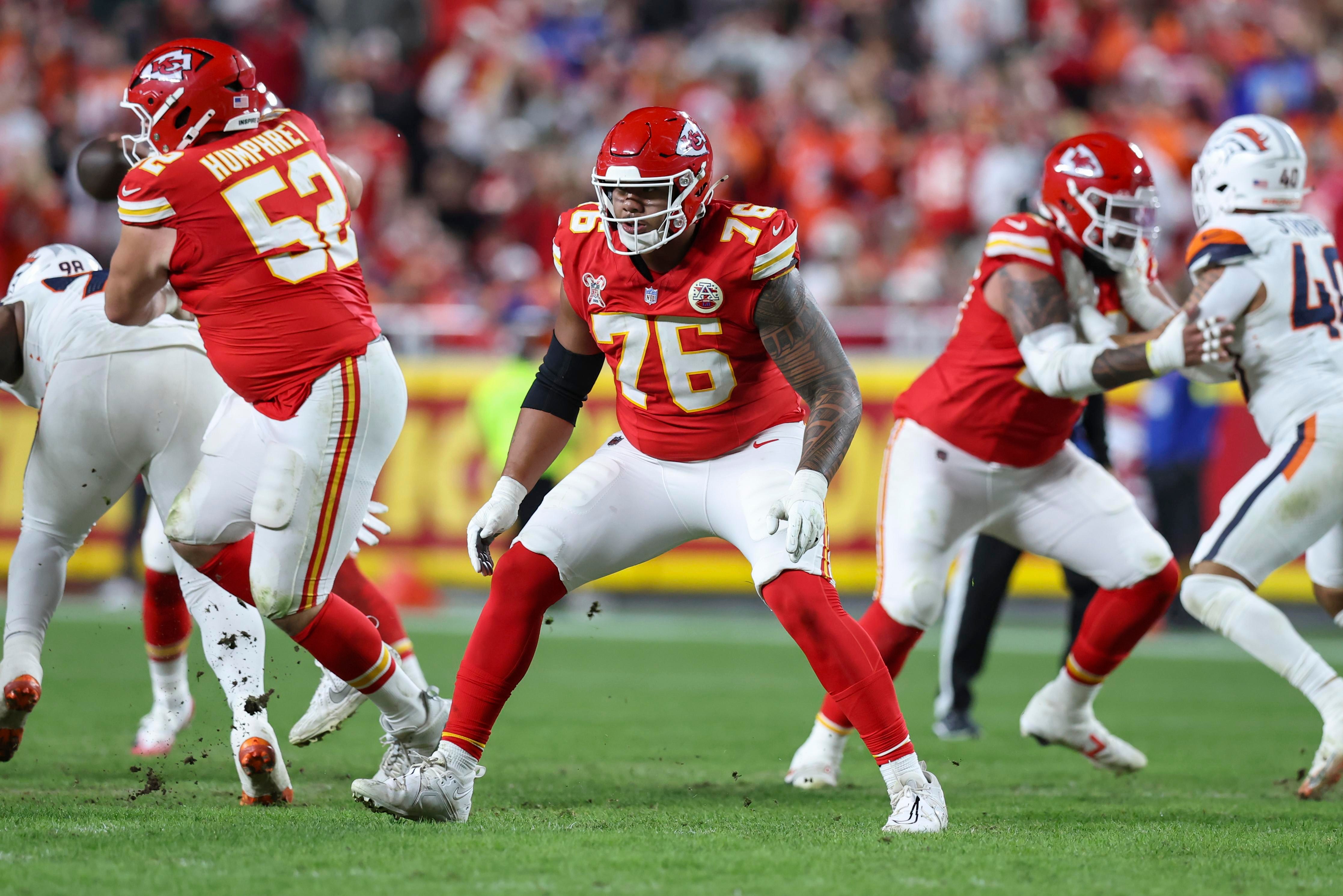 Jogadores da linha ofensiva dos Chiefs protegem o quarterback durante uma jogada.