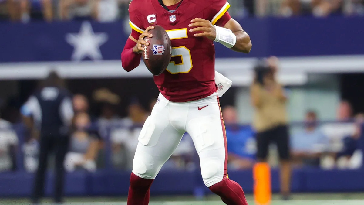 Jayden Daniels, quarterback do Washington Commanders, prepara um passe.