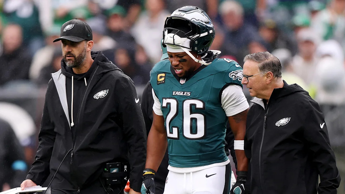 Saquon Barkley, com a camisa 26 dos Eagles, recebe atendimento na lateral do campo.