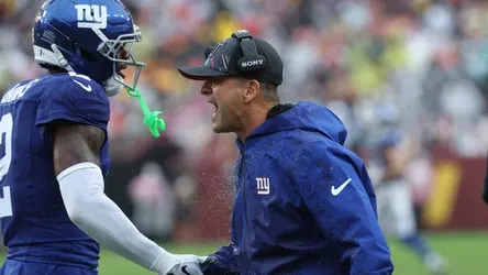 John Harbaugh conversa com um jogador dos Giants.