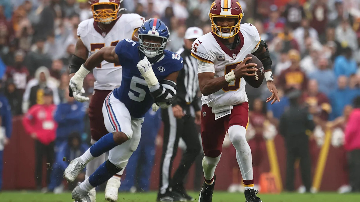 Jayden Daniels corre para um touchdown diante de Kayvon Thibodeaux em Landover, em 11 de outubro de 2026.