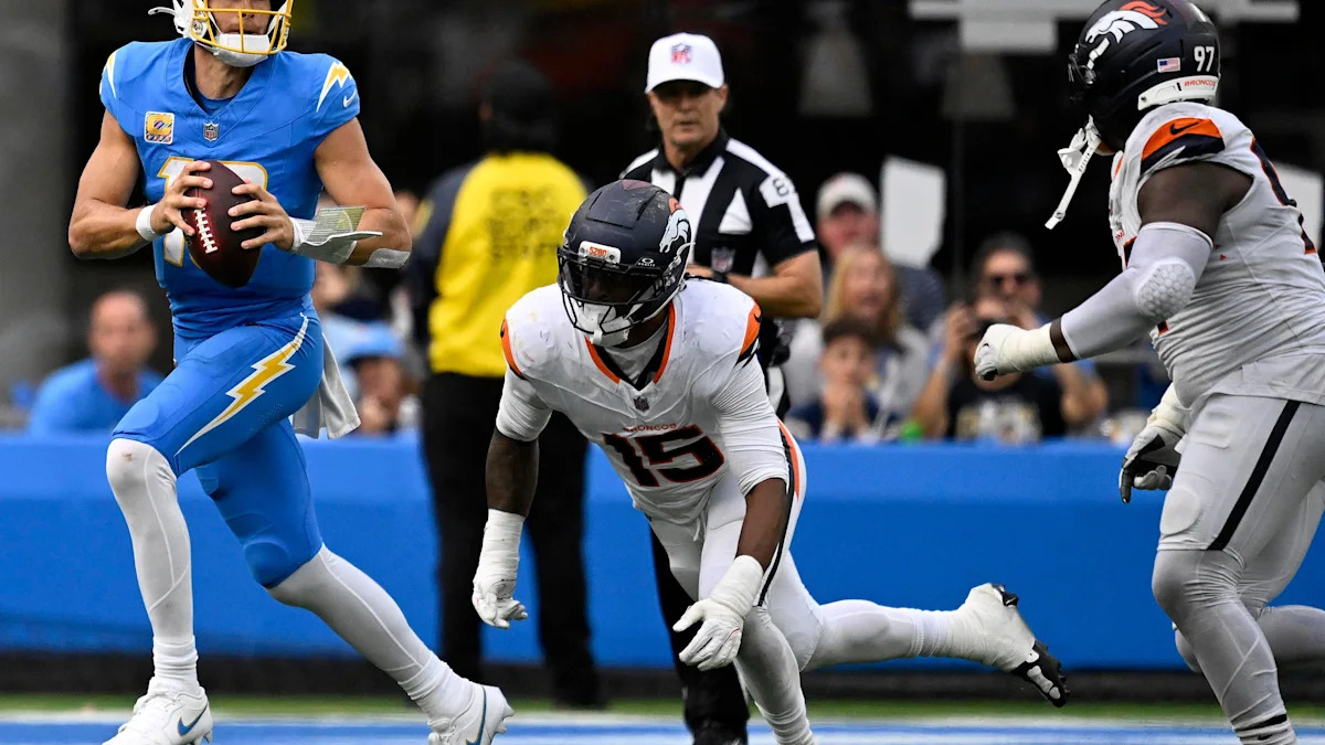 Justin Herbert e defensores dos Broncos durante o jogo em Inglewood, em 11 de outubro de 2026.