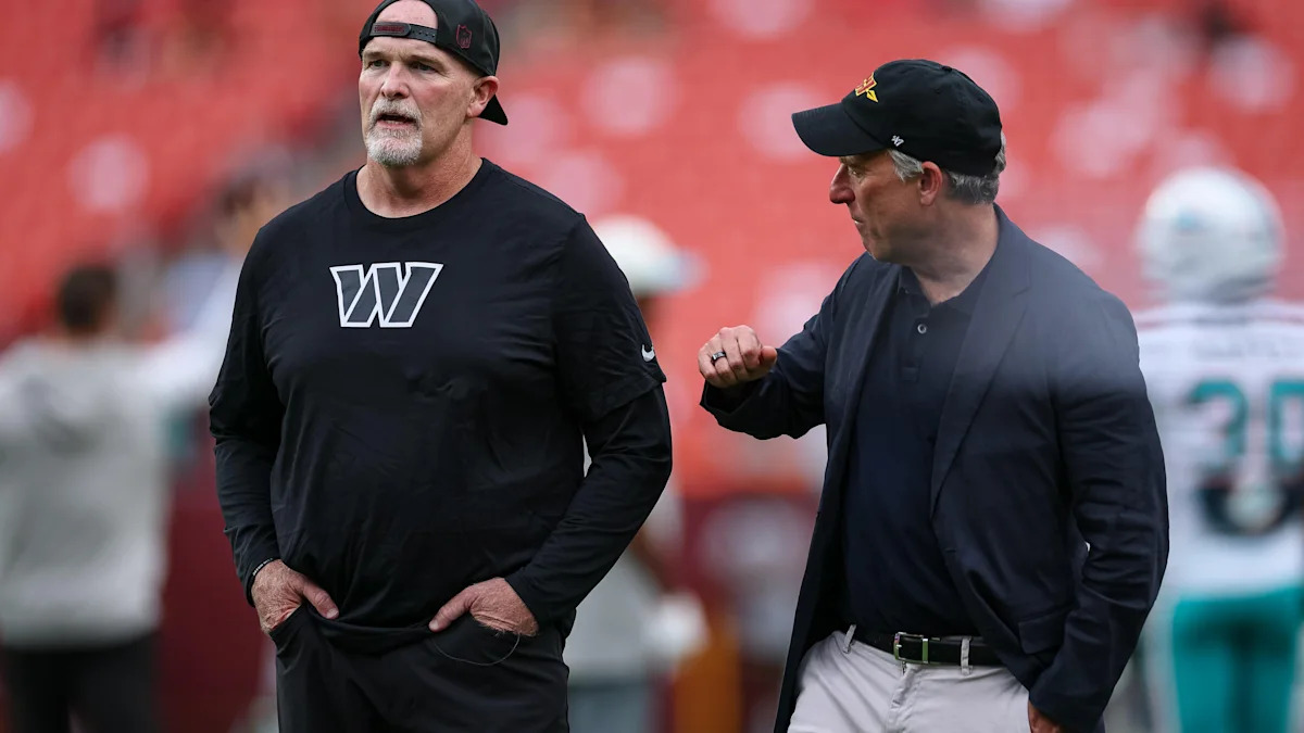 Dan Quinn e Josh Harris conversam antes de uma partida dos Commanders.