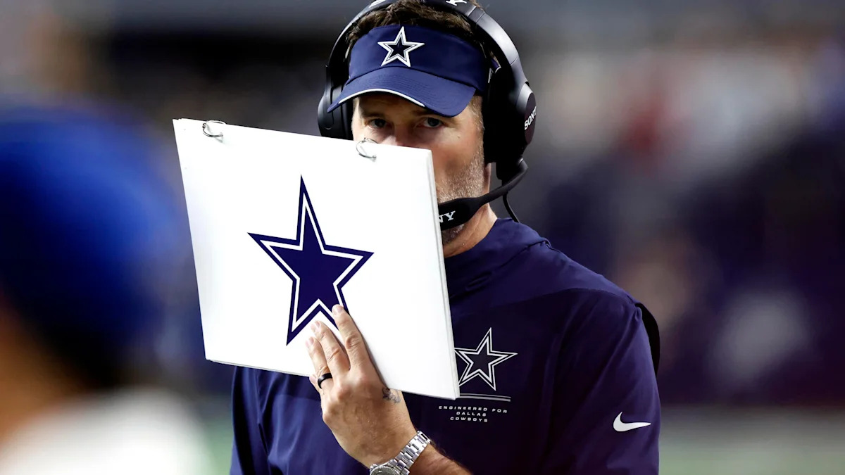 Brian Schottenheimer observa a partida à beira do campo.