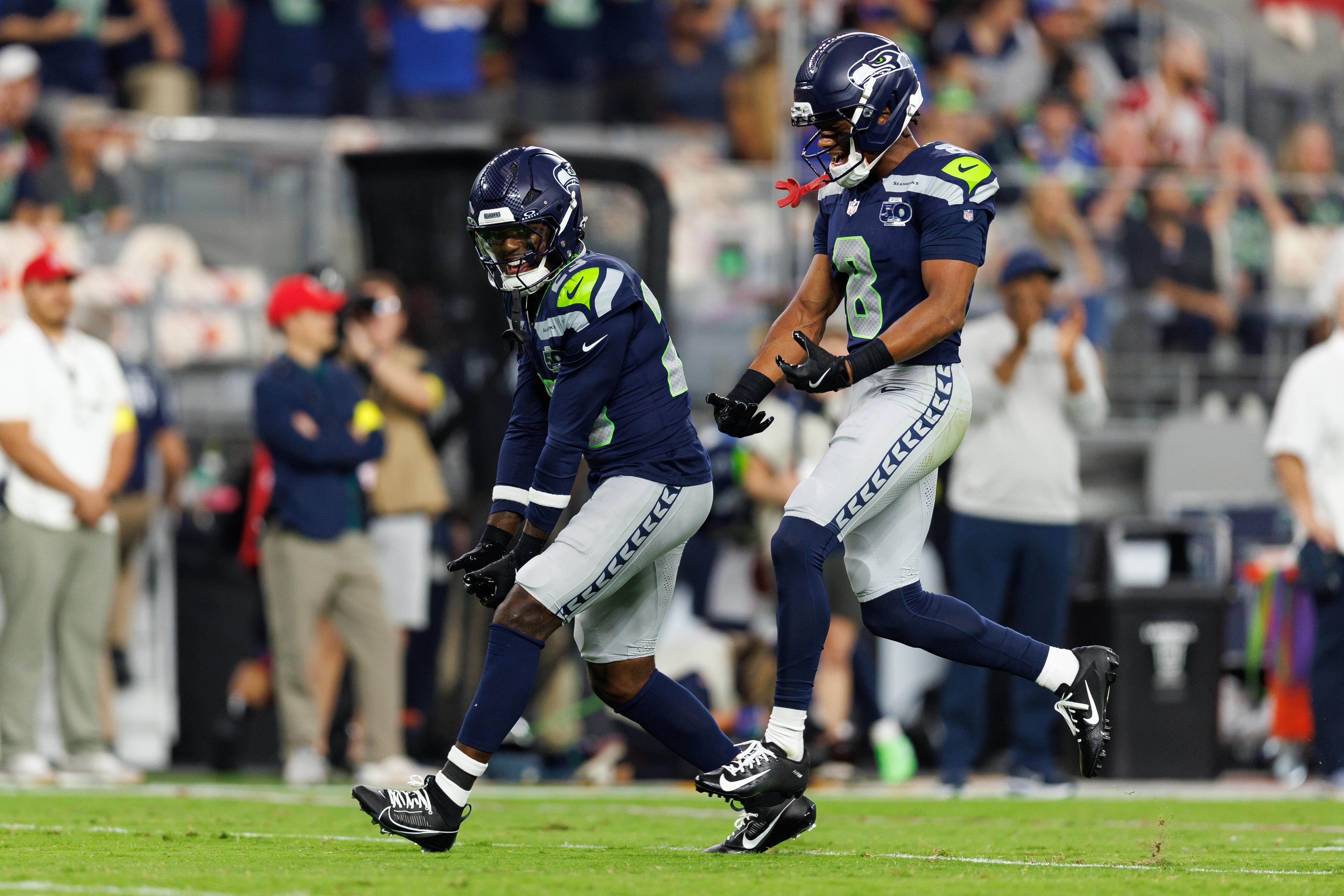 Coby Bryant comemora com D’Anthony Bell no jogo dos Seahawks contra os Cardinals, em Glendale, em 25 de setembro de 2025.